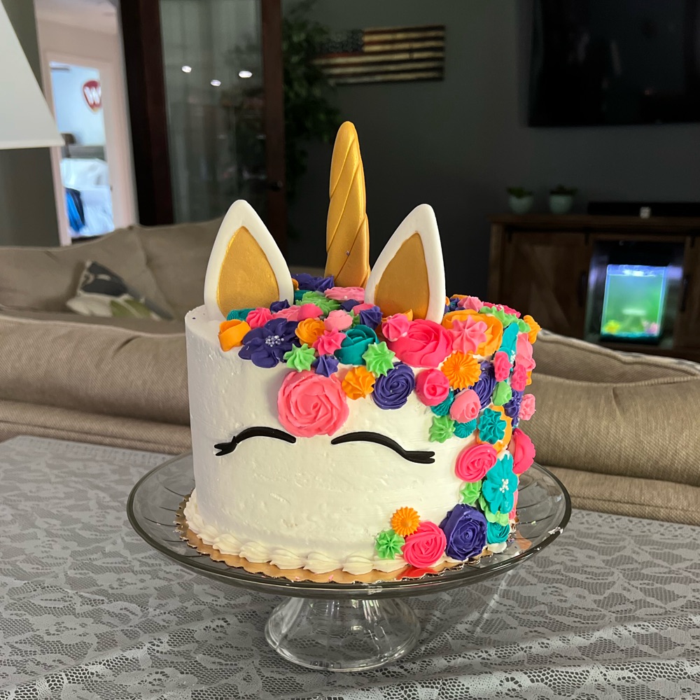 Unicorn cake with gold horn and rainbow buttercream flowers
